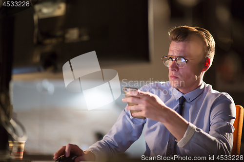 Image of man using mobile phone in dark office