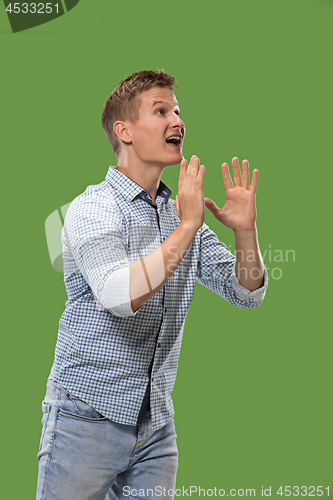 Image of Isolated on green young casual man shouting at studio