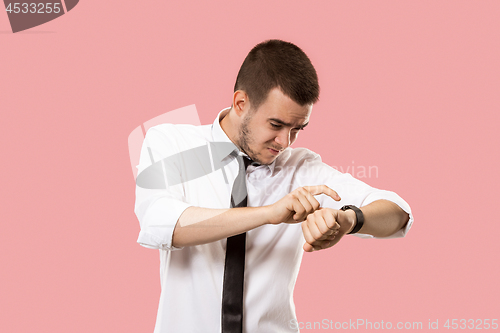 Image of Handsome businessman checking his wrist-watch Isolated on pink background