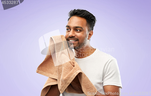 Image of indian man using bath towel over violet background