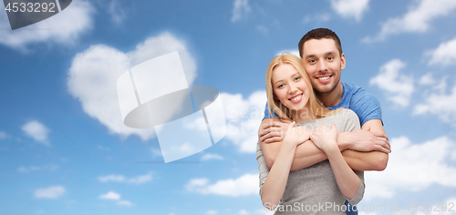 Image of couple hugging over sky and heart shaped cloud