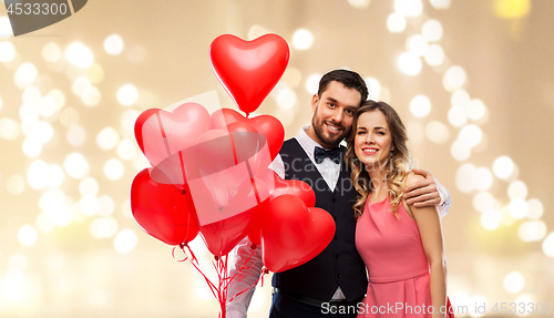 Image of happy couple with red heart shaped balloons