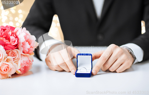 Image of man with diamond engagement ring in blue gift box