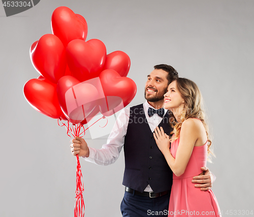 Image of happy couple with red heart shaped balloons