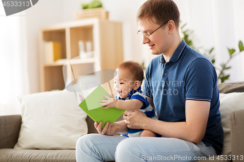 Image of happy father and little baby son with book at home