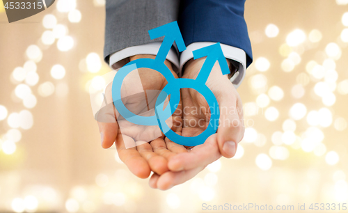 Image of close up of happy male gay couple with love symbol