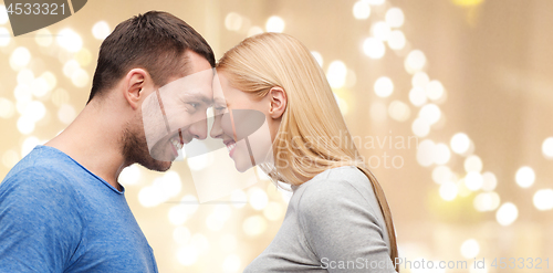 Image of couple forehead to forehead over festive lights