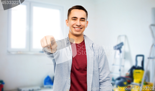 Image of man pointing to you over home repair background