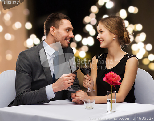 Image of young couple with glasses of wine at restaurant