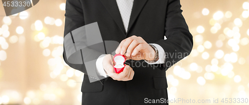 Image of man with diamond engagement ring in red gift box