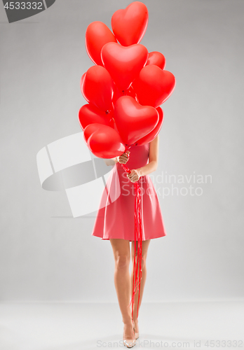 Image of young woman with red heart shaped balloons