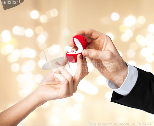 Image of man giving diamond ring to woman on valentines day