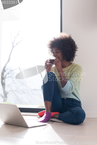 Image of black woman in the living room on the floor