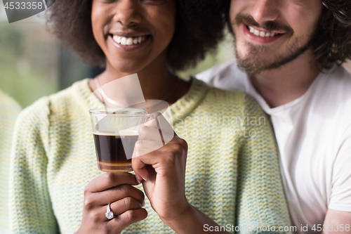 Image of happy multiethnic couple relaxing at modern home indoors