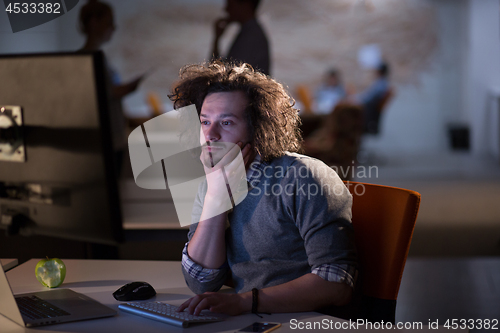 Image of man working on computer in dark office