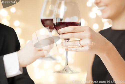Image of close up of engaged couple drinking red wine