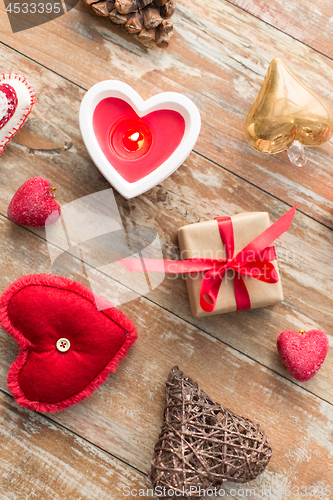 Image of christmas gift, heart shaped decorations, candle