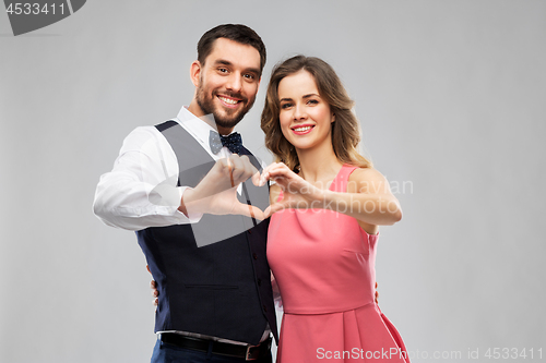 Image of happy couple making hand heart on valentines day