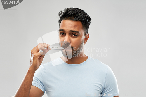 Image of man measuring oral temperature by thermometer