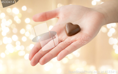 Image of close up of hand with heart shaped chocolate candy