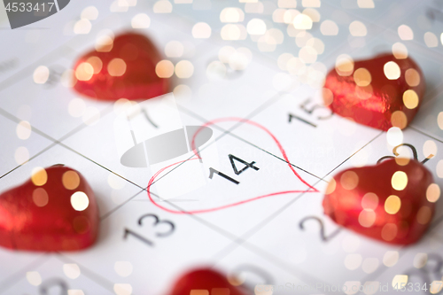 Image of close up of calendar and heart shaped candies