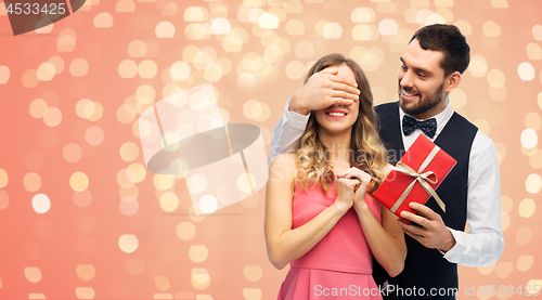 Image of happy man giving woman surprise present