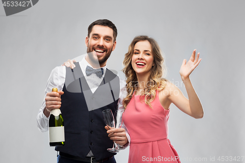 Image of happy couple with bottle of champagne and glasses