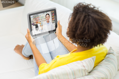 Image of woman having video chat with pharmacist on tablet 