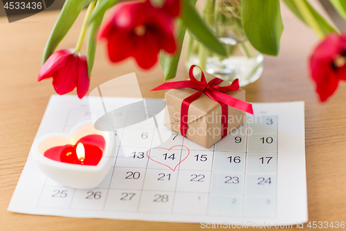 Image of gift box, calendar sheet and flowers on table