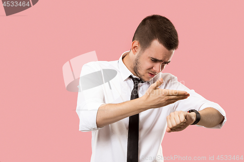 Image of Handsome businessman checking his wrist-watch Isolated on pink background