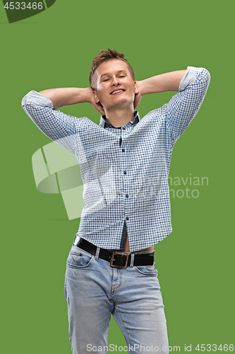 Image of The happy business man standing and smiling against green background.