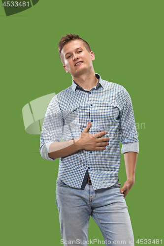 Image of The happy business man standing and smiling against green background.