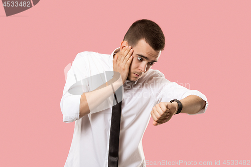 Image of Handsome businessman checking his wrist-watch Isolated on pink background