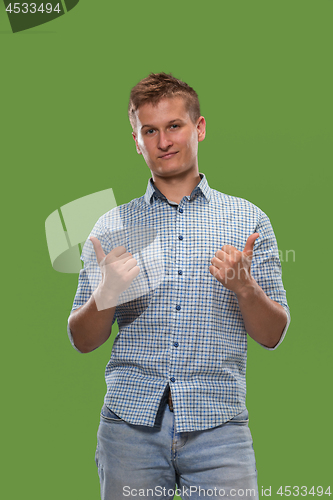 Image of The happy businessman standing and smiling against green background.