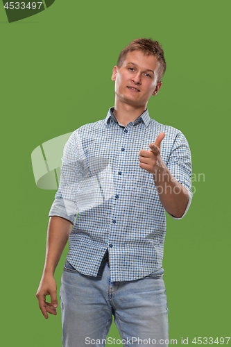 Image of The happy businessman standing and smiling against green background.