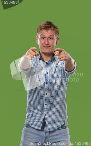 Image of The happy business man point you and want you, half length closeup portrait on green background.
