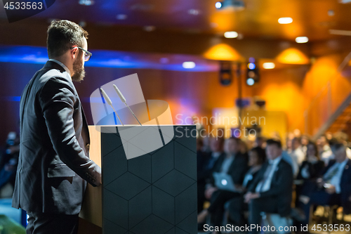 Image of Public speaker giving talk at business event.