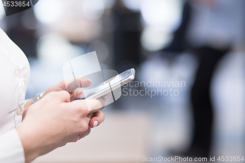 Image of Elegant Woman Using Mobile Phone in startup office building