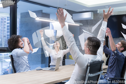 Image of startup Group of young business people throwing documents