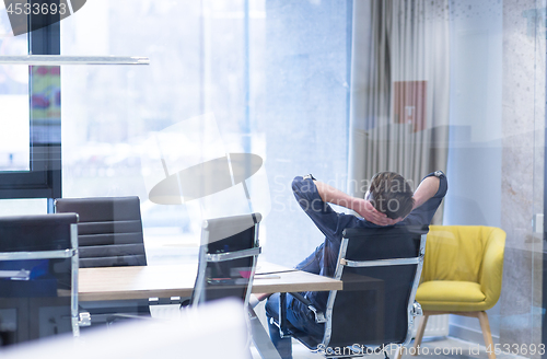 Image of young businessman relaxing at the desk