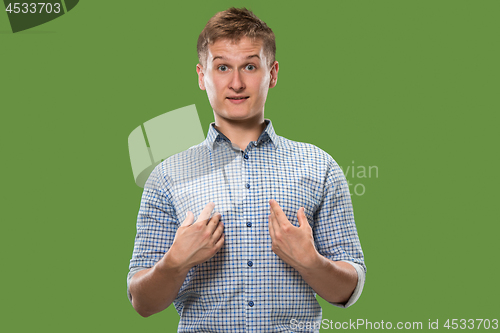 Image of Suspiciont. Doubtful pensive man with thoughtful expression making choice against green background