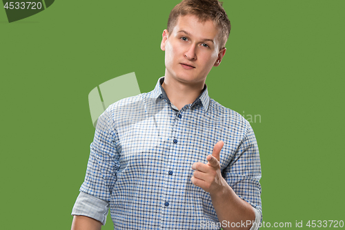 Image of The happy businessman standing and smiling against green background.