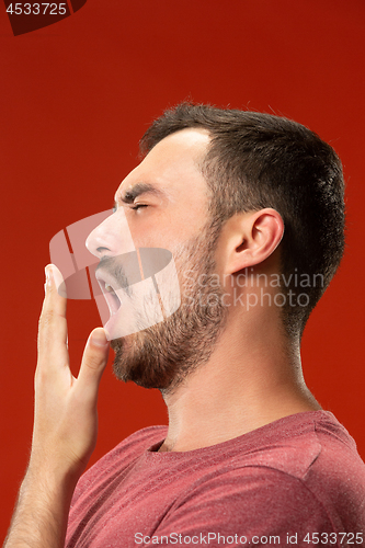 Image of Beautiful bored man bored isolated on red background