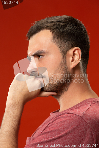 Image of Beautiful man looking suprised and bewildered isolated on red