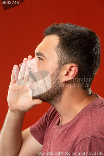 Image of Isolated on red young casual man shouting at studio