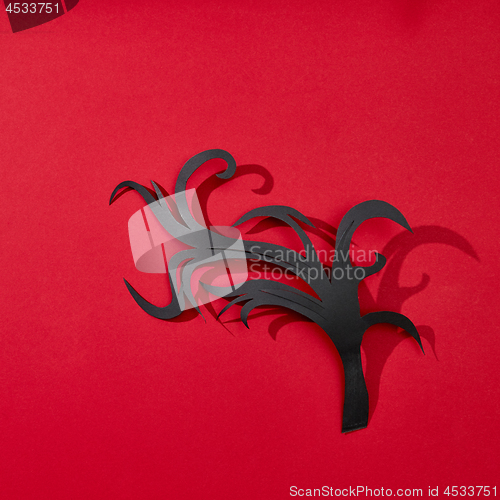Image of Creative greeting card handcraft from paper in the form of a branch on a red background with reflection of shadows and copy space for text. Flat lay