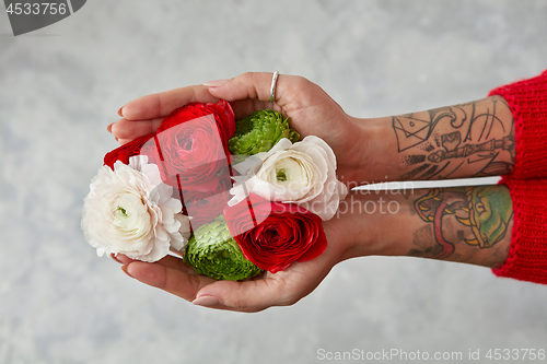 Image of girl with a tattoo on her hands holding a bouquet of flowers