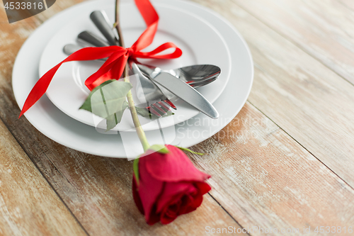 Image of close up of red rose flower on set of dishes