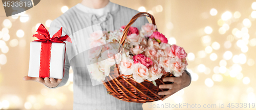 Image of man with basket of flowers and gift over lights