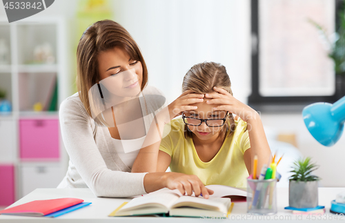 Image of mother helping daughter with difficult homework